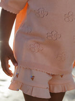 a little girl wearing a peach shots with small prints of ice-cream