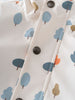 Close-up of white fabric with blue and orange tree print and snap buttons Printed Raincoat - Forest Adventure Ecru Boys