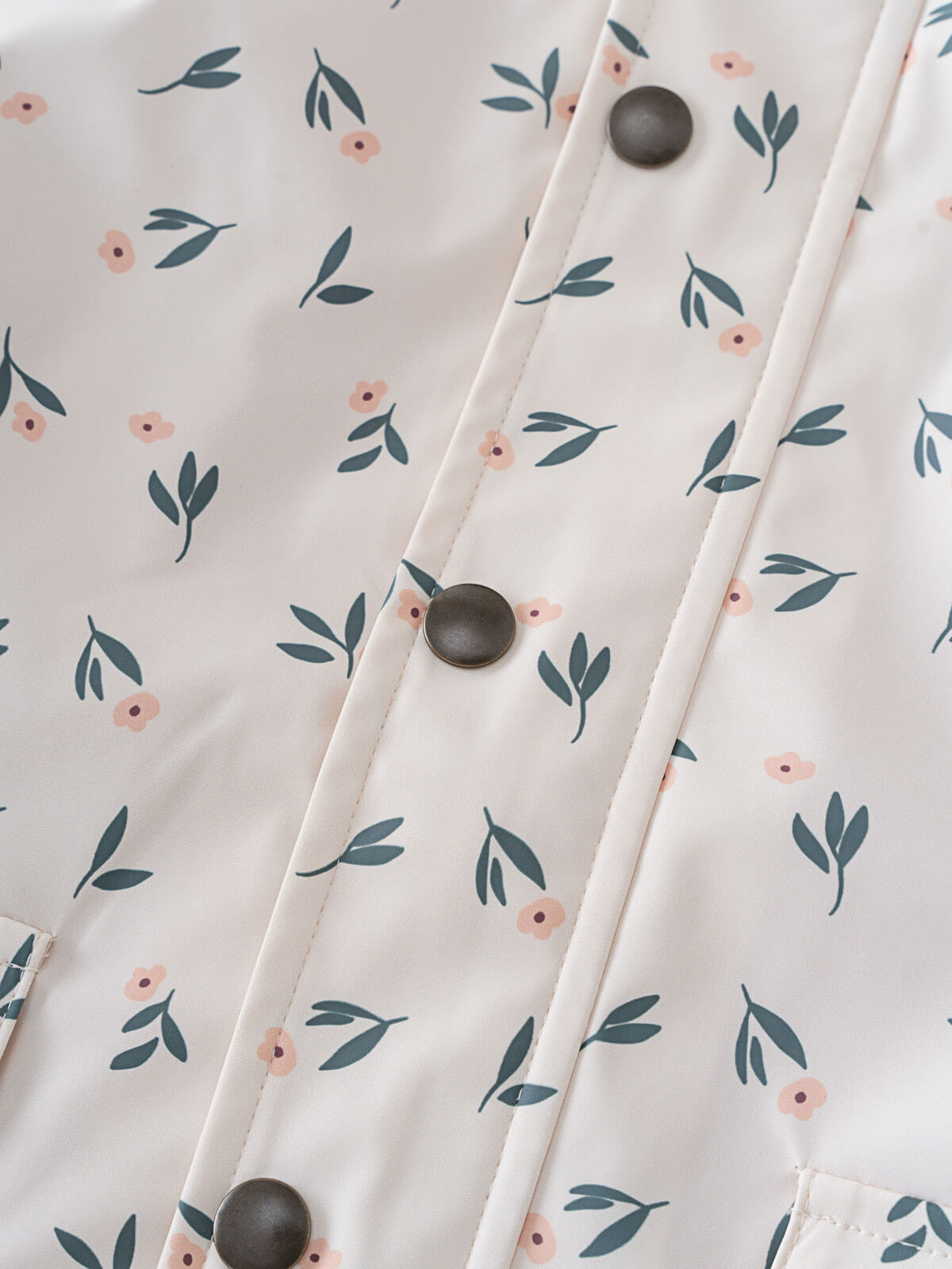 Close-up of fabric with floral print and dark buttons on placket Printed Raincoat - Wild Flowers Ecru Girls