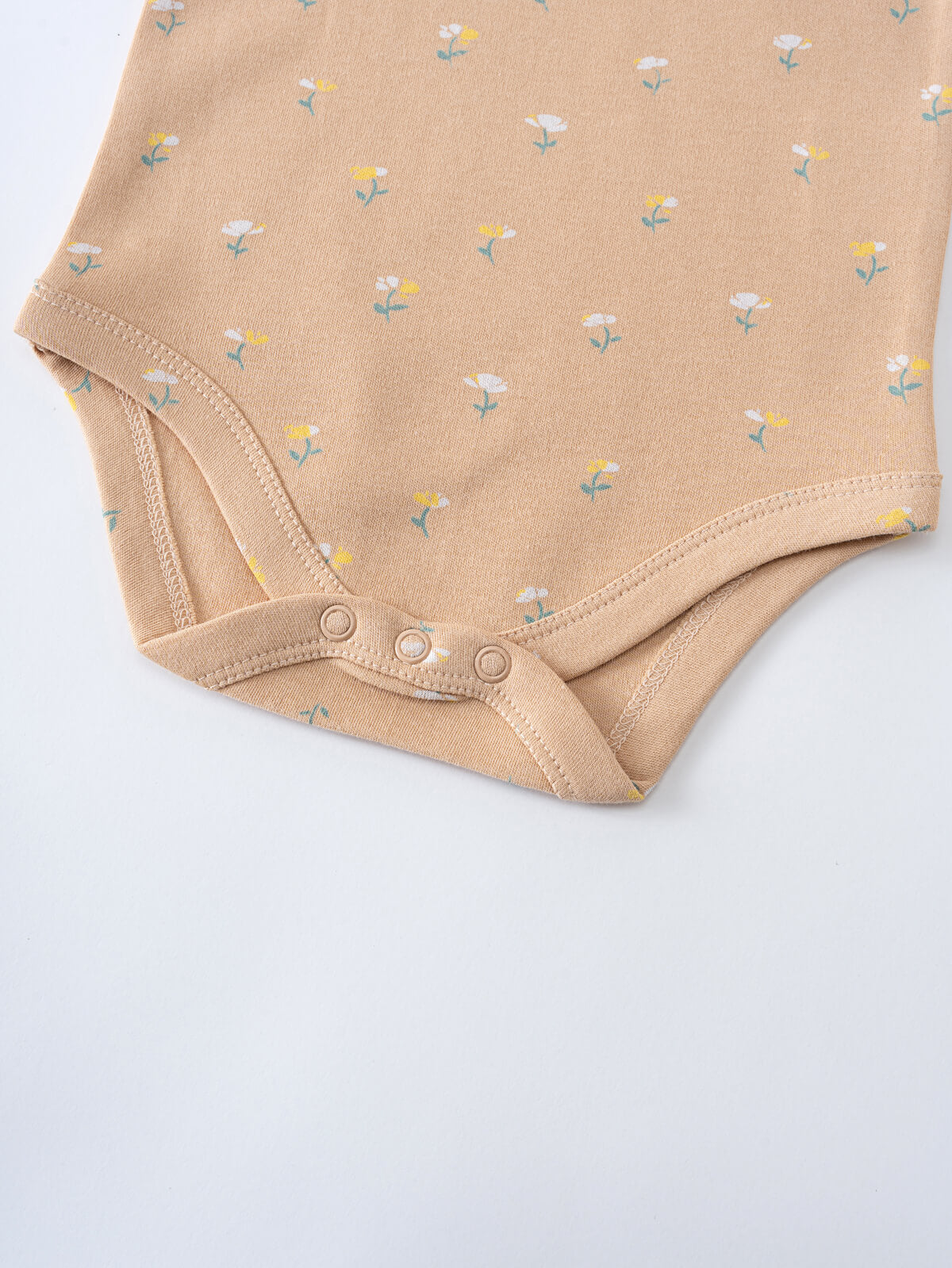 Close-up of a beige onesie with small floral print and snap closures Printed Short Sleeve Bodysuit - Floral Bloom Baby girl