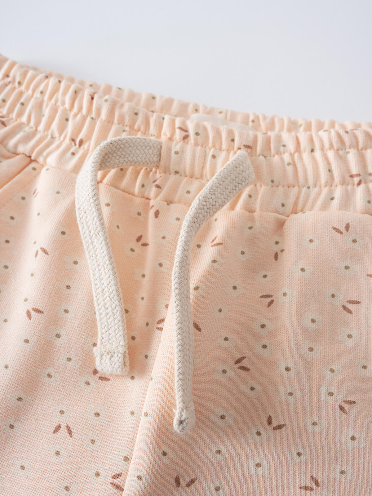 Close-up of elastic waistband with drawstring on peach patterned fabric Printed Shorts - Flower Power Girls