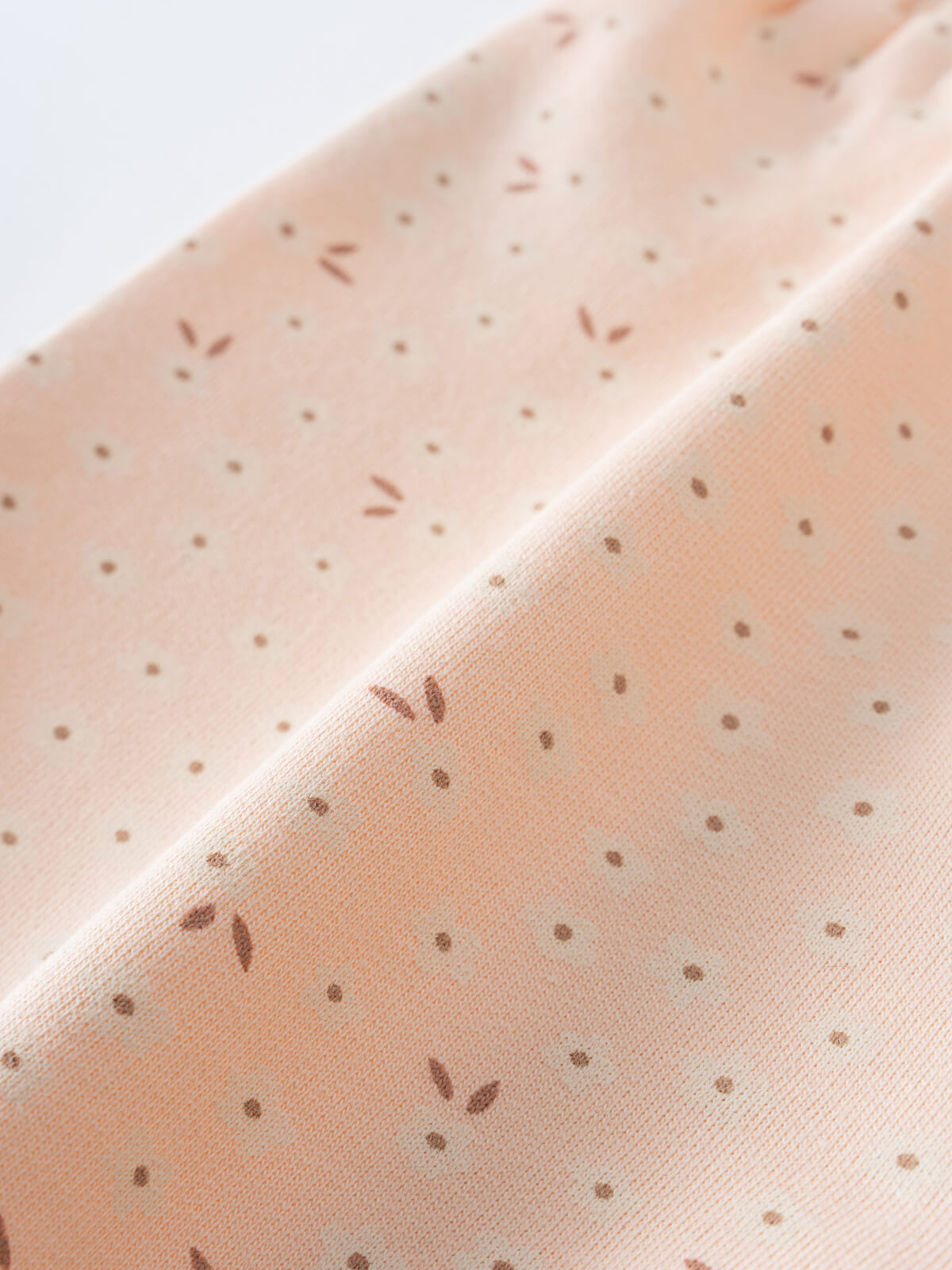 Close-up of peach fabric with small brown floral dot pattern Printed Shorts - Flower Power Girls
