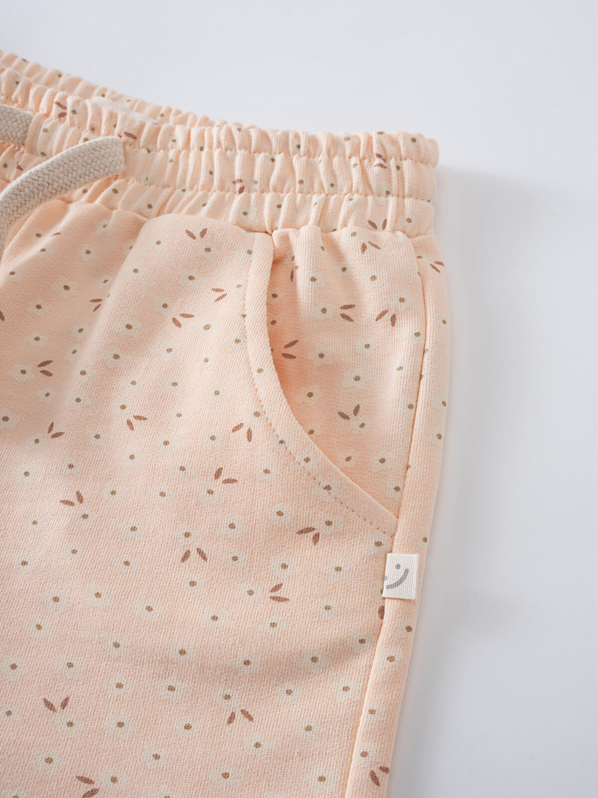 Close-up of peach shorts with small floral print and elastic waistband Printed Shorts - Flower Power Girls