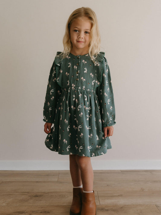 Young girl wearing a green dress with a floral pattern against a plain background Printed Woven Dress - Forest Gathering Balsam Girls