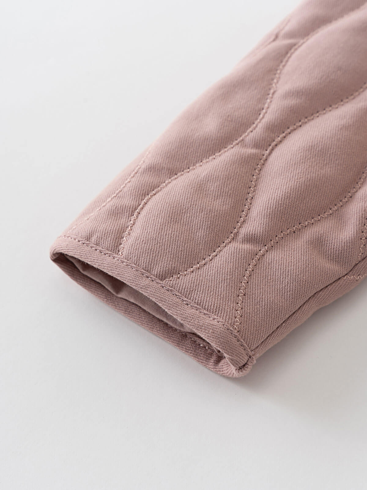 Close-up of a pink quilted fabric on a light gray background Quilted Jacket - Blush Baby girl