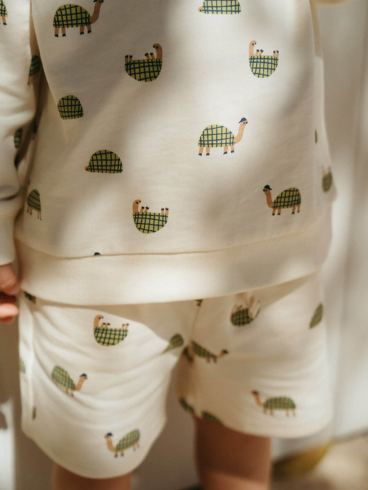 Children's sweatshirt set with green animal pattern on a plain background