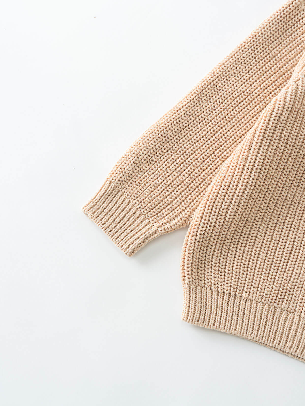 Beige knitted sleeve on a light background