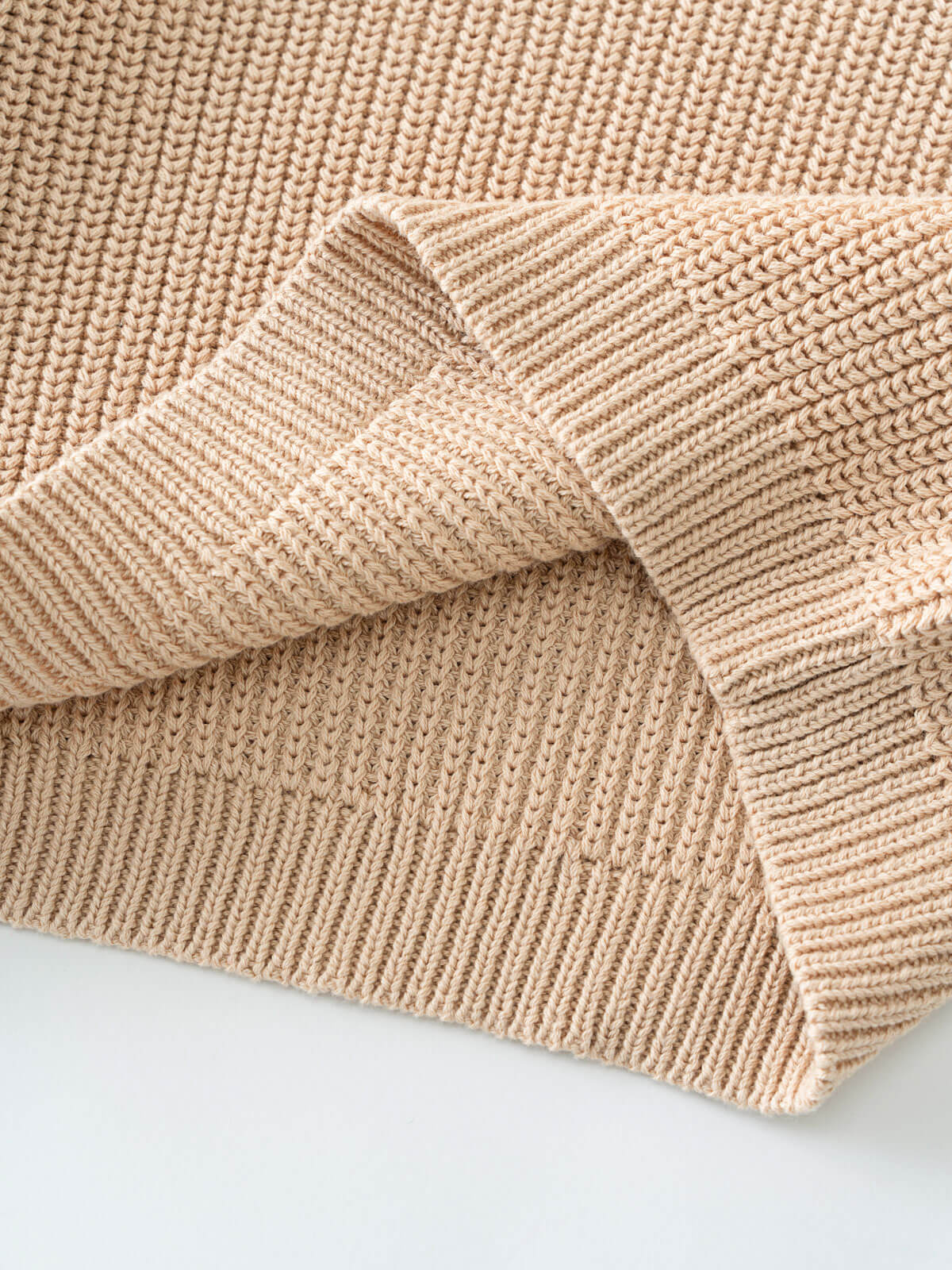 Close-up of beige knitted fabric on a light background