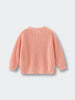 Pink knitted sweater on a light gray background