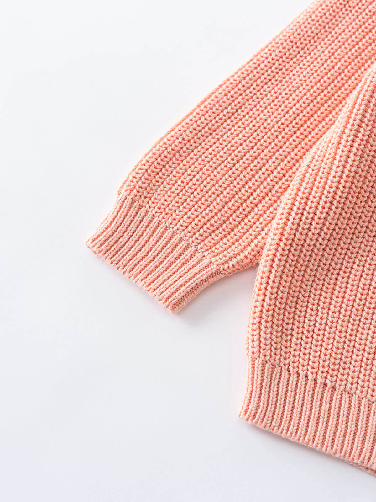 Close-up of a pink knitted garment on a light gray background
