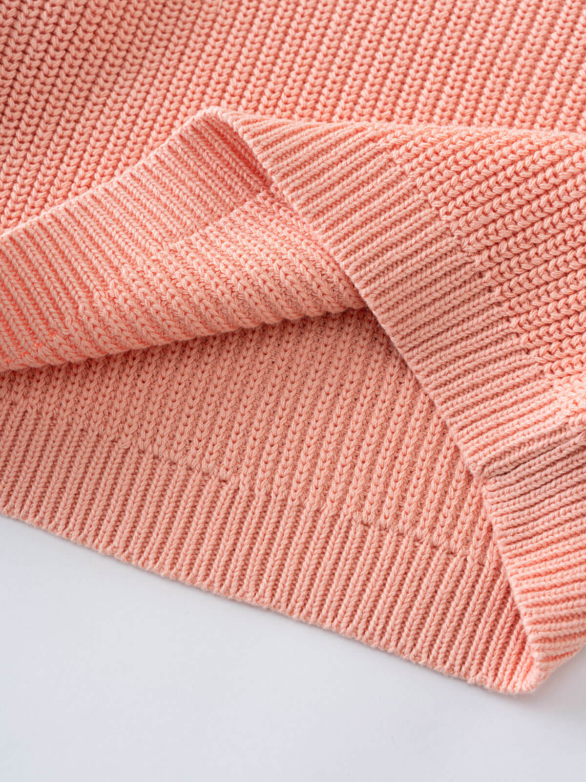 Close-up of a pink knitted fabric on a light gray background