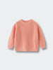 Pink sweater on a light gray background