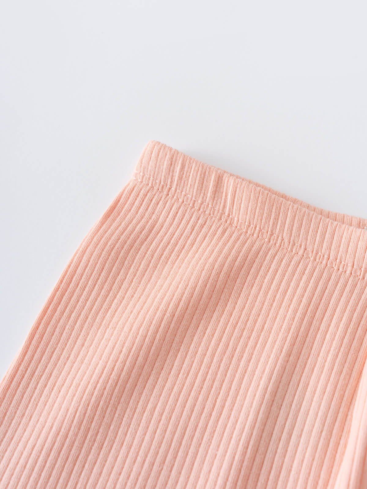 Close-up of peach ribbed fabric with elastic waistband on gray background Ribbed Leggings - Toasted Peach Girls