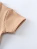 Close-up of beige ribbed knit fabric showing texture and finished edge detail Ribbed Short Sleeve One Piece - Sand Baby boy