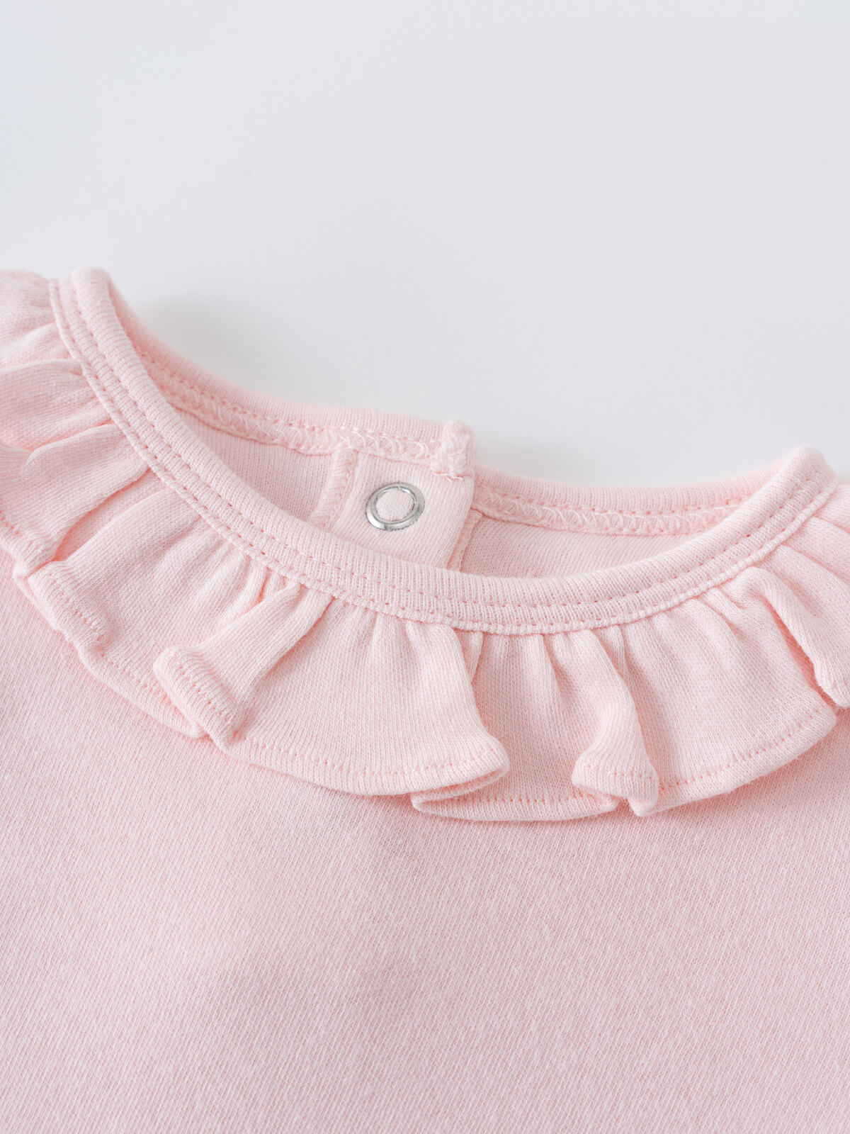 Close-up of a pink baby bodysuit with a ruffled collar and snap closure Ruffle Short Sleeve Bodysuit - Candy Floss Baby girl