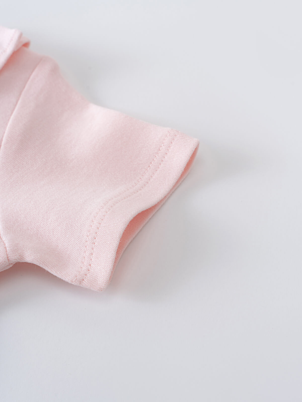 Close-up of a pale pink bodysuit sleeve with stitched seam detail Ruffle Short Sleeve Bodysuit - Candy Floss Baby girl