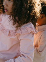 Young girl with curly hair wearing a pink eyelet ruffle collar top Ruffle Top - Mallow Girls