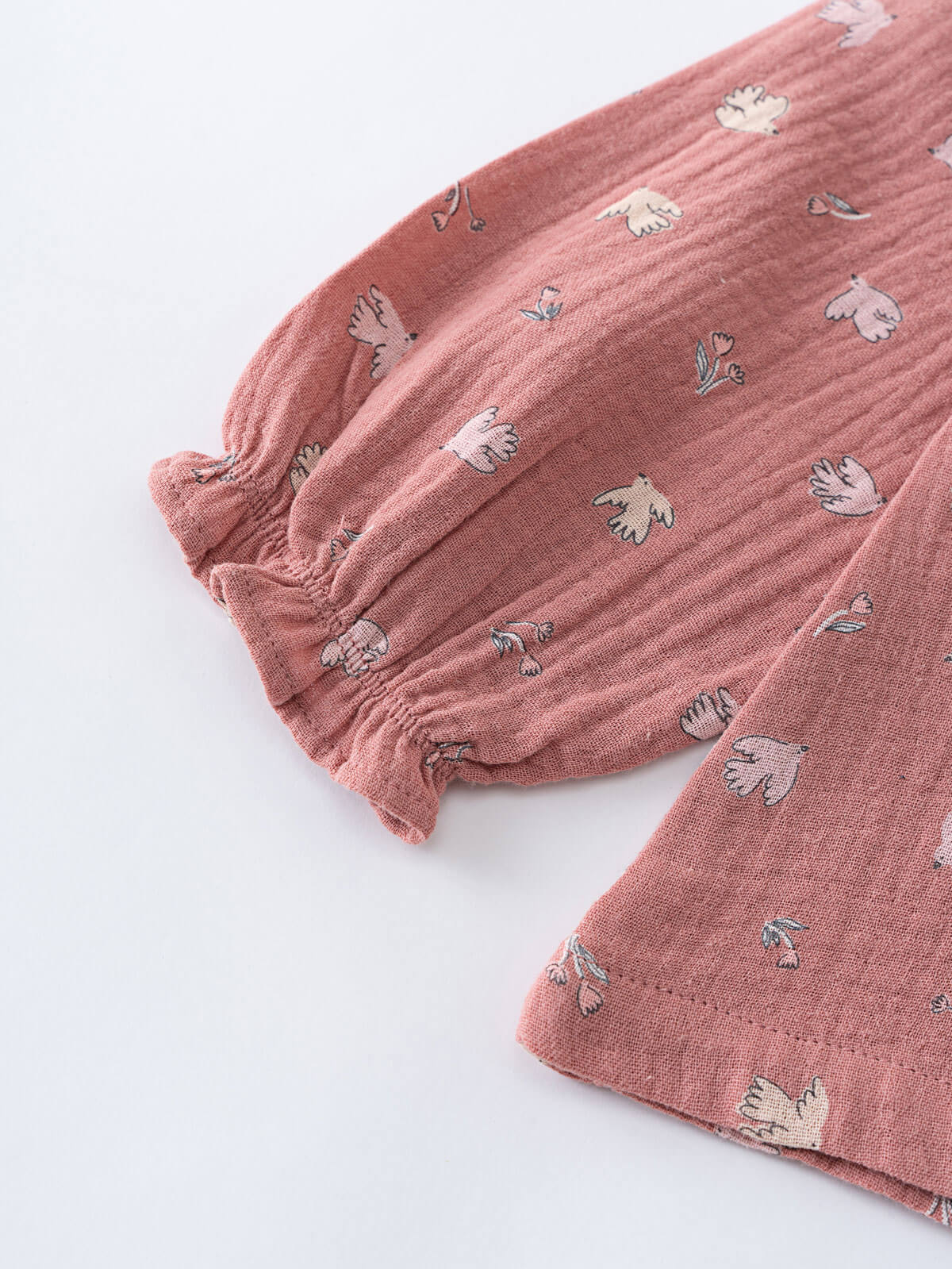 Pink textured fabric with small animal prints on a white background Ruffle Woven Blouse - Bird And Blossom Rosehip Girls