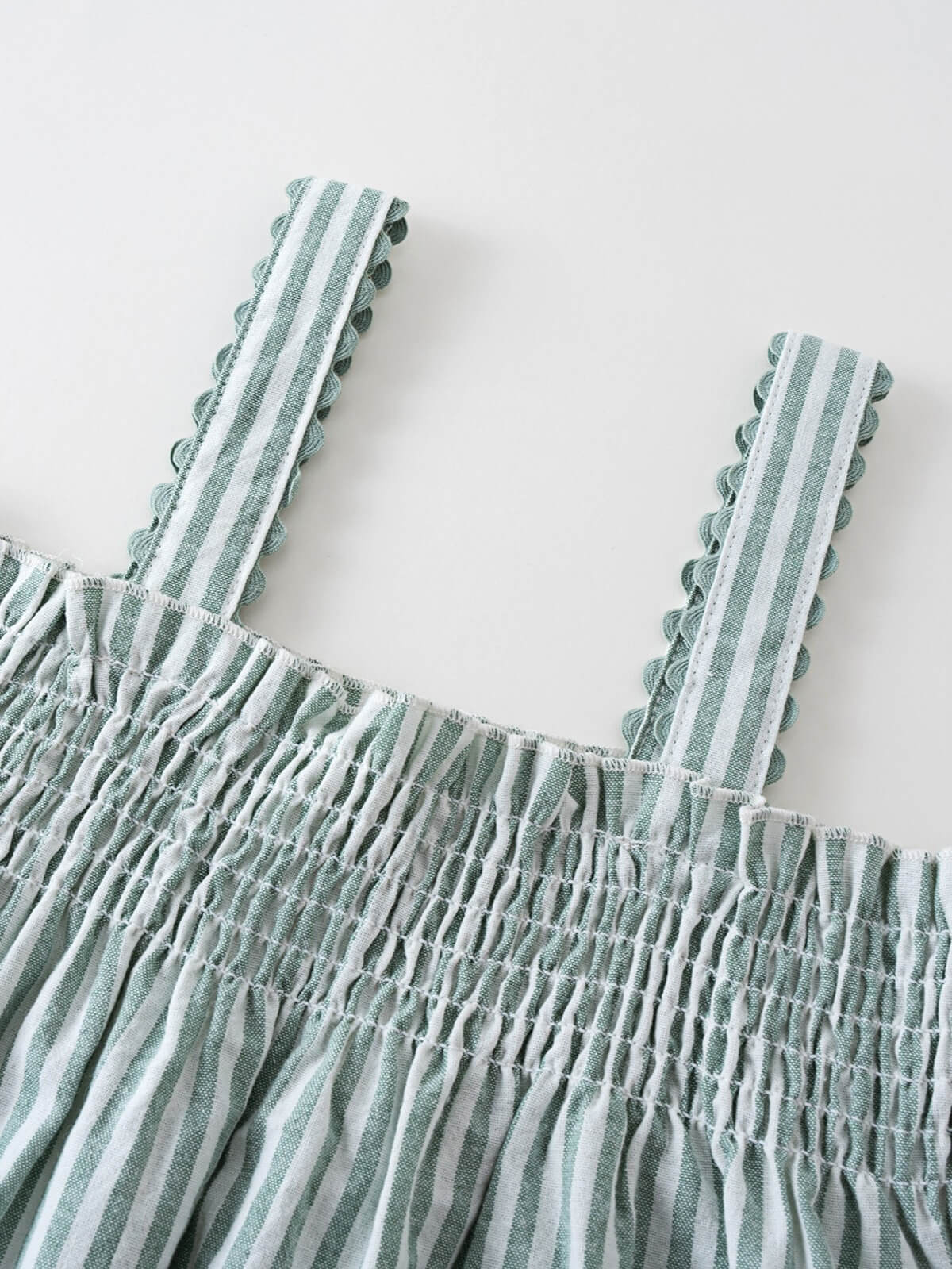 Close-up of green and white striped fabric with smocked detail and scalloped straps Shirred Top - Mint Stripe Girls