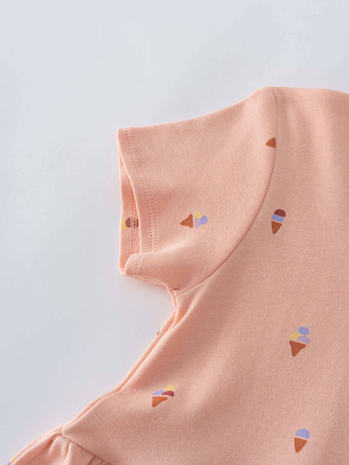 Close-up of peach fabric with small ice cream cone print pattern Short Sleeve Dress - Ice Creams Girls