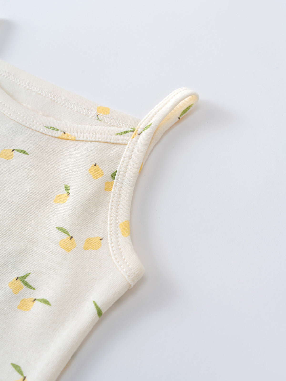 Close-up of cream bodysuit with yellow lemon print and ribbed trim Sleeveless Bodysuit - Lemons Baby girl