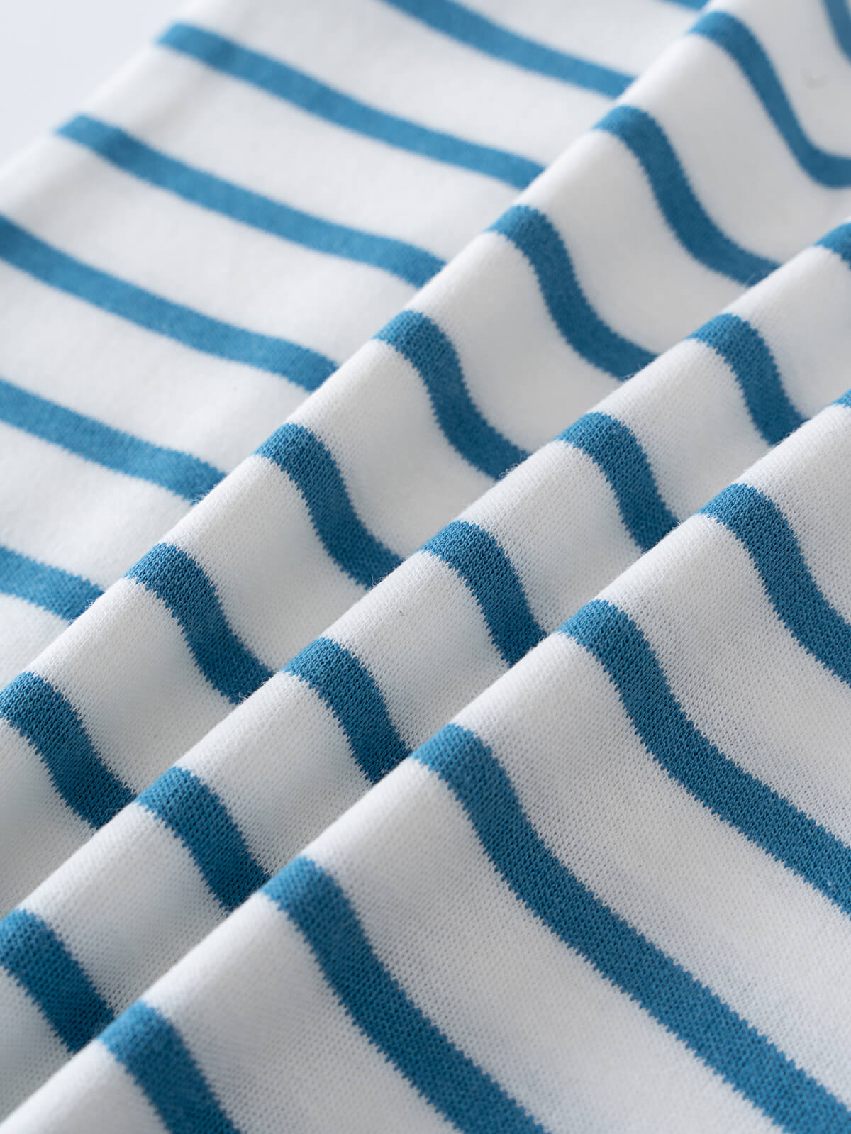 Close-up of folded white fabric with blue horizontal stripes Sleeveless Tee - Blue Stripe Boys