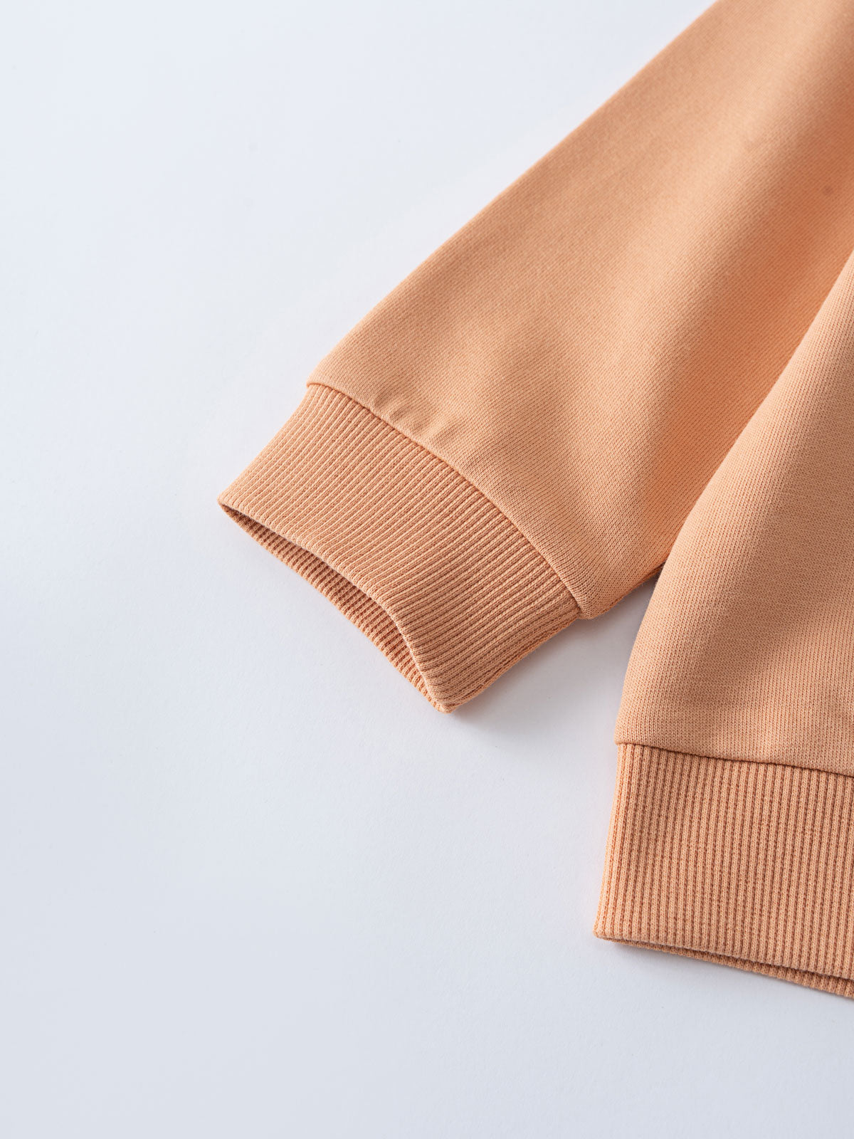 Close-up of peach-colored sweatshirt sleeves showing ribbed cuffs Sweatshirt - Yes Sailing Boys