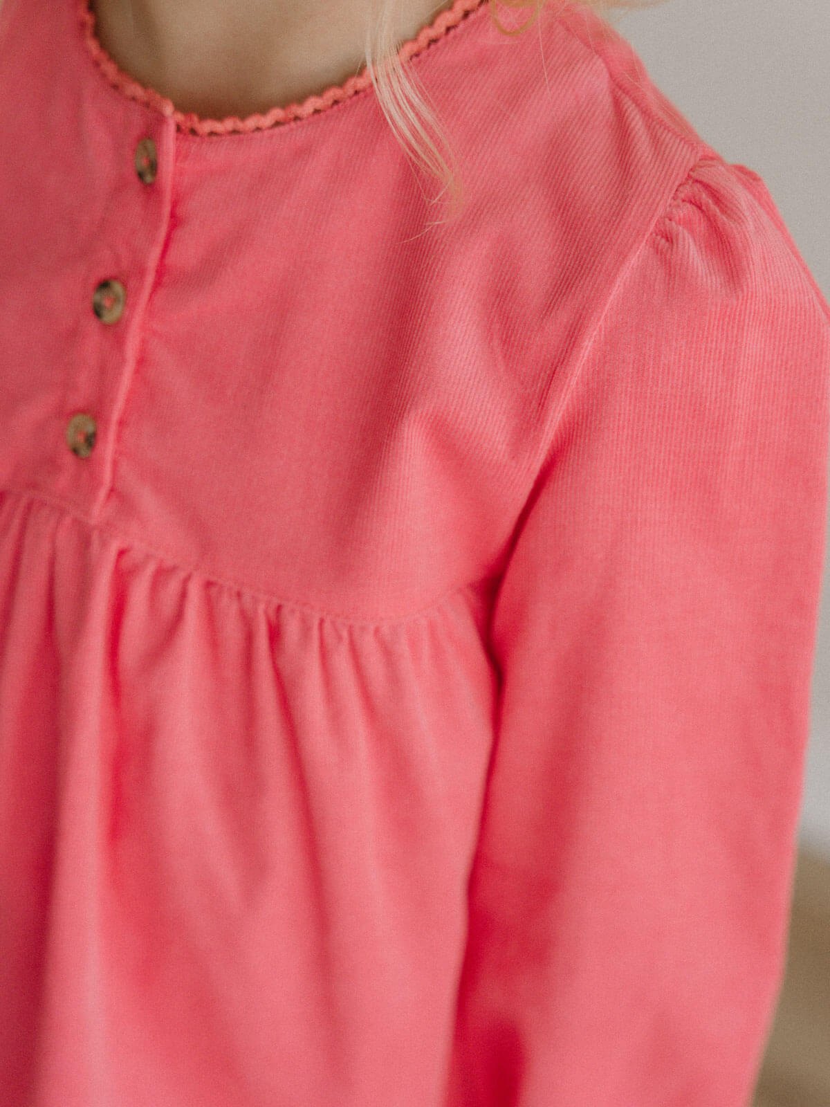 Close-up of a pink long-sleeve top with buttons on a neutral background Three Button Blouse - Cloudberry Girls