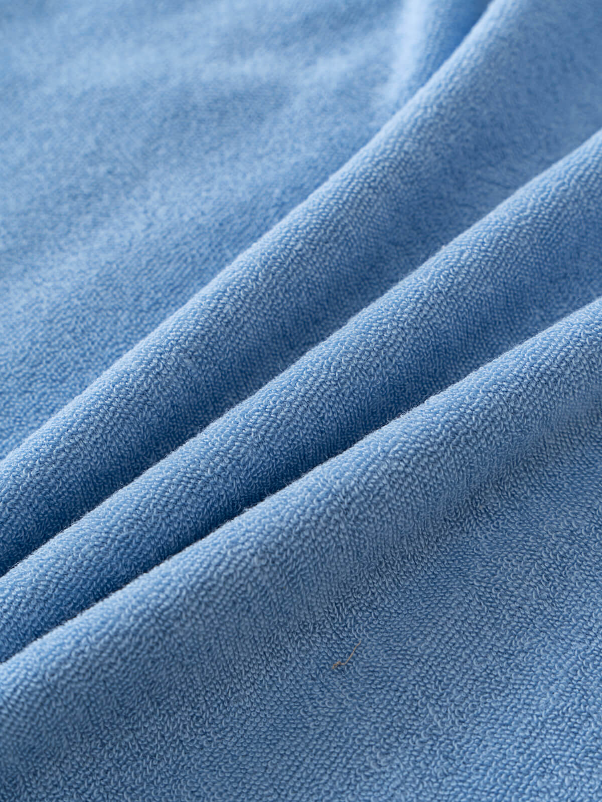 Close-up of light blue terry cloth fabric with soft textured folds Towelling Tee Shirt - Sky Blue Boys
