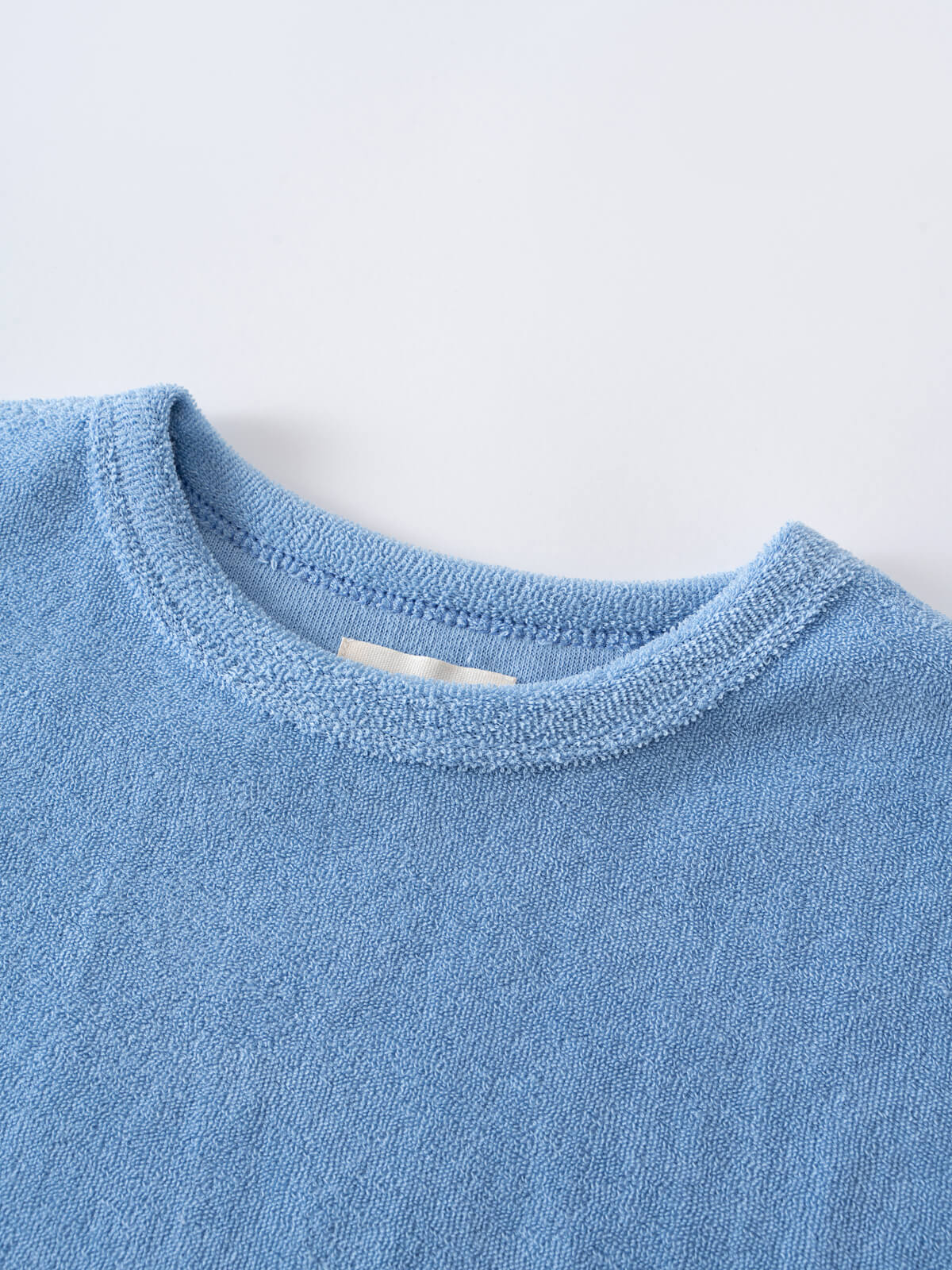 Close-up of a light blue textured fabric shirt neckline Towelling Tee Shirt - Sky Blue Boys