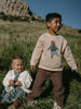 Boy wearing beige sweatshirt with bear graphic and brown pants outdoors Twill Pants - Spruce Boys