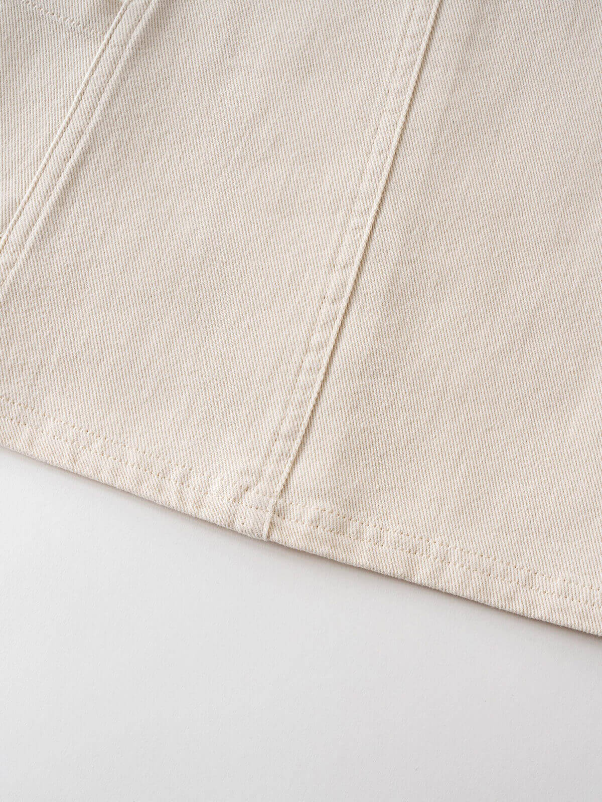 Close-up of cream-colored twill fabric with diagonal stitching detail Twill Pinafore Dress - Salt Girls