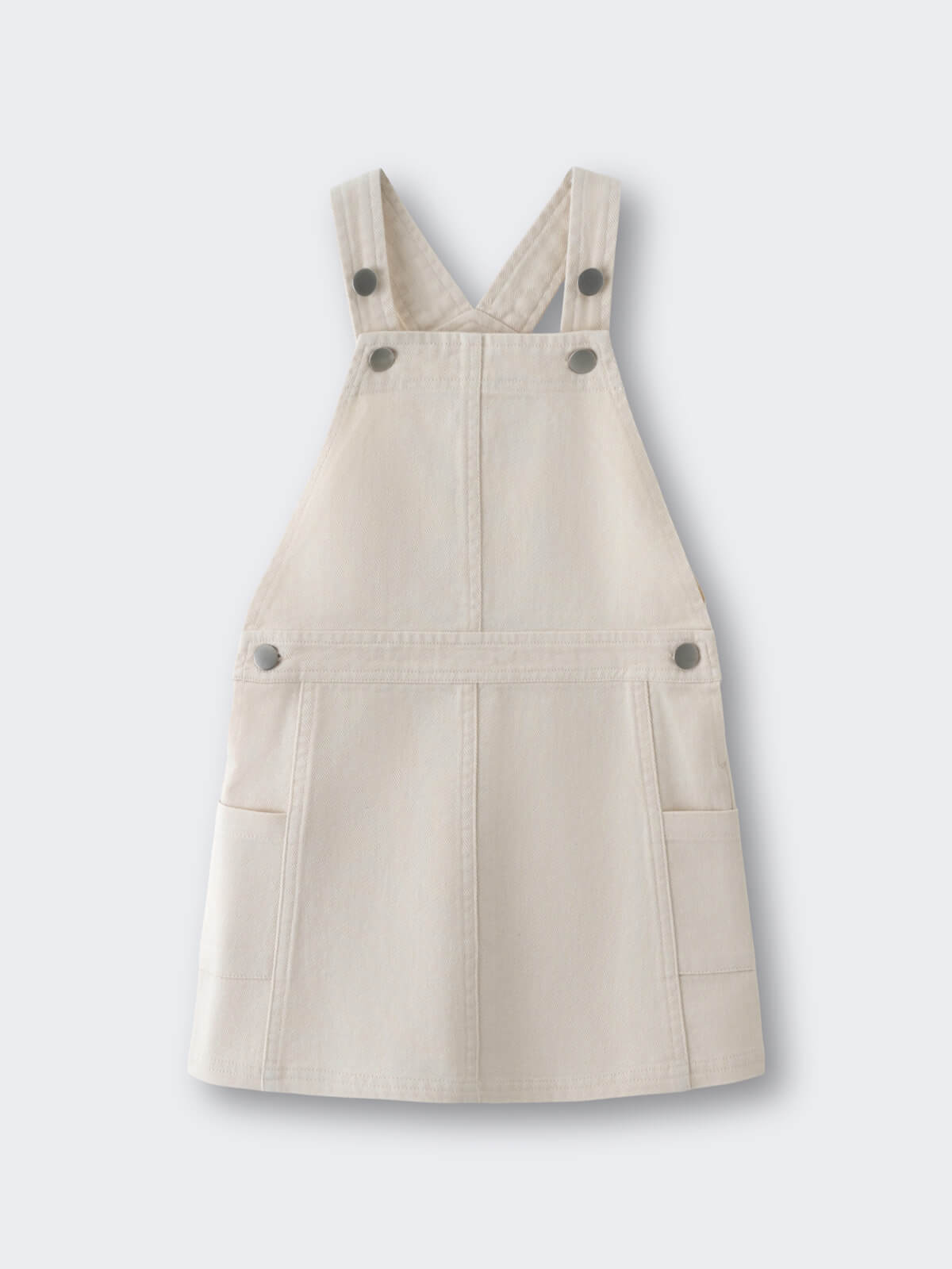 Cream-colored overall dress with crossed back straps and button details Twill Pinafore Dress - Salt Girls
