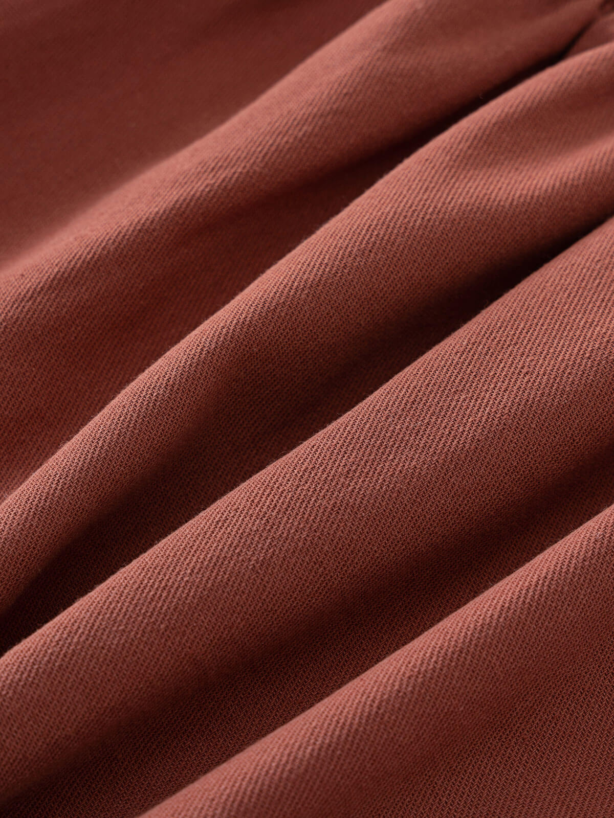 Close-up of draped terracotta-colored woven fabric with visible diagonal texture Woven Skirt - Rosehip Girls