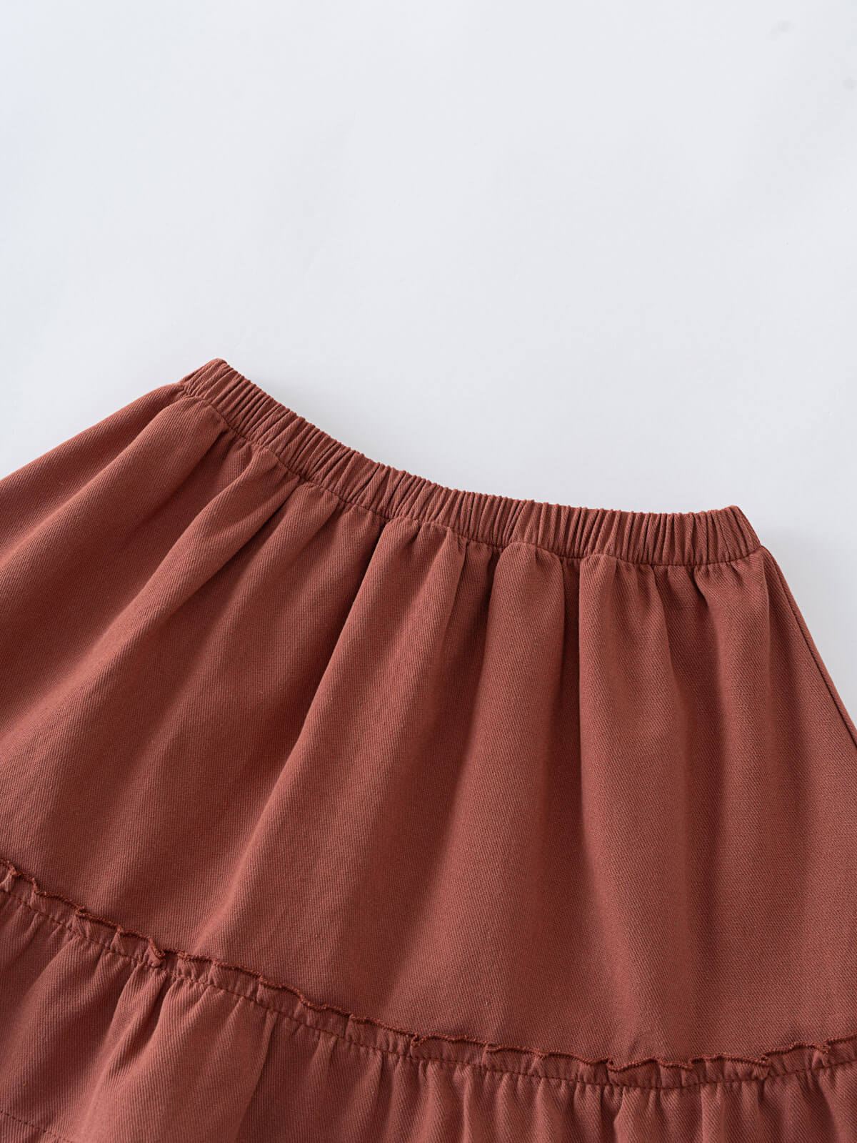 Close-up of a rust-colored skirt with elastic waistband and ruffled hem Woven Skirt - Rosehip Girls