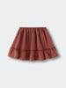 Rust-colored skirt with elastic waistband and ruffled hem on flat surface Woven Skirt - Rosehip Girls