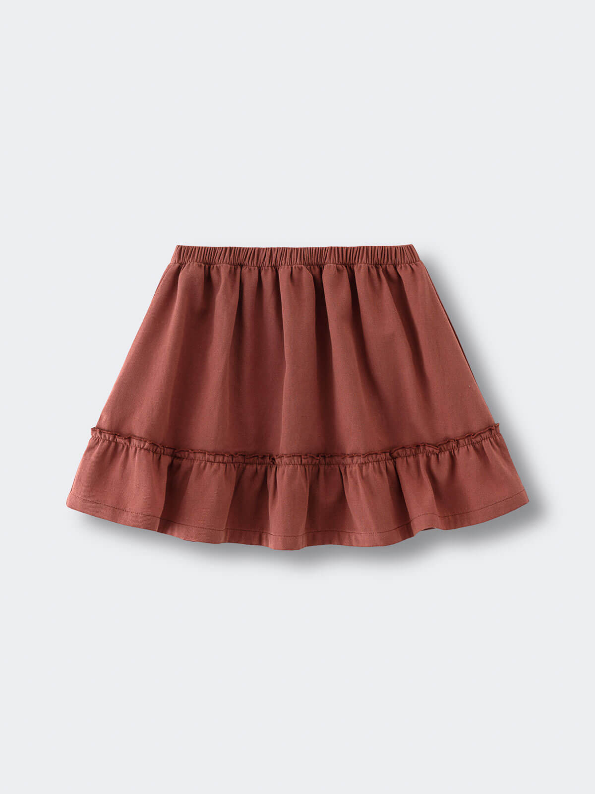 Rust-colored skirt with elastic waistband and ruffled hem on flat surface Woven Skirt - Rosehip Girls