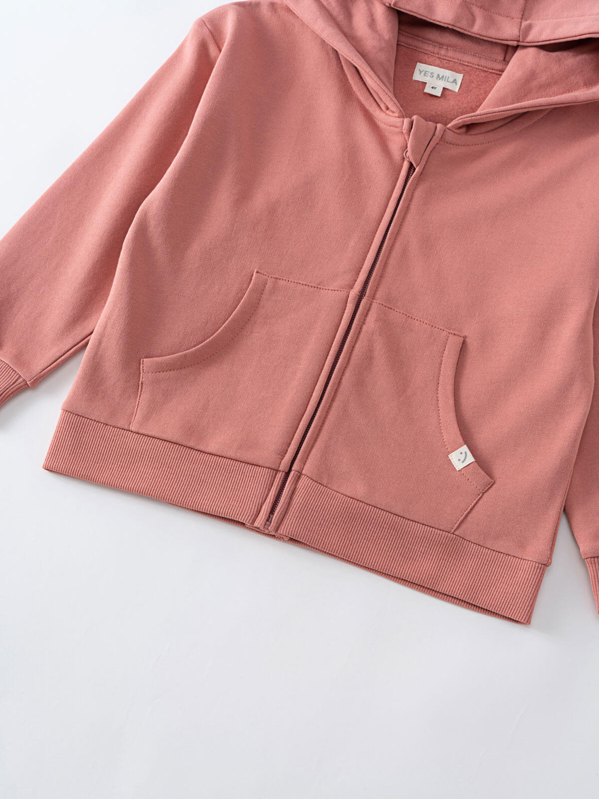 Close-up of a pink zip-up hoodie with front pockets and ribbed hem Zip Hoodie - Rosehip Boys