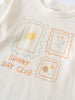 Close-up of a cream-colored shirt with three postage stamp graphics and text Zoey Long Sleeve Tee - Sunny Club Day Girls